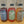 Three bottles of Blue Mesa, Strawberry Basil, and High Desert Dirty shrubs on a wooden surface with a wooden background.