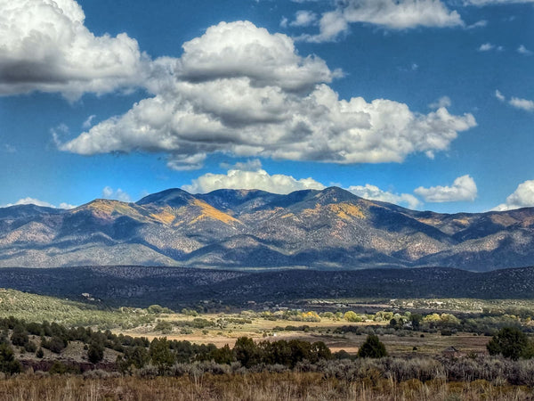 Scenic view of mountains with a blue sky and white clouds